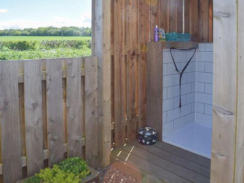 a bathroom with a shower with a wooden fence at Thistle Cottage in Mauchline
