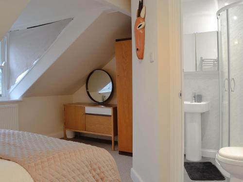 1 dormitorio con cama, lavabo y espejo en Gilberts Warrant, en Keswick