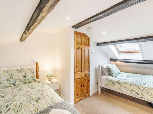 a bedroom with a bed and a window at Quince Cottage in Flookburgh