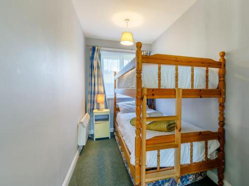a bedroom with two bunk beds and a window at Surfers Hideaway in Woolacombe