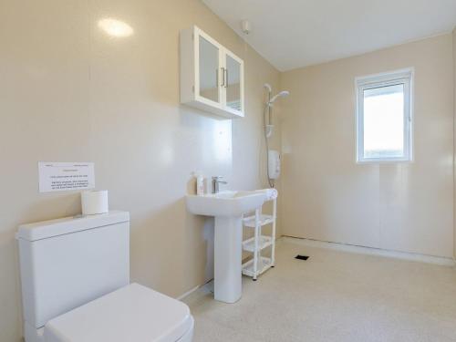 a bathroom with a toilet and a sink at Surfers Hideaway in Woolacombe