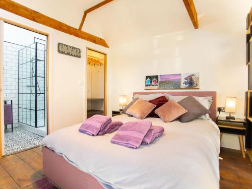 a bedroom with a large bed with purple pillows on it at North & Back in North Walsham