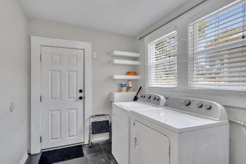 a white laundry room with a washing machine and a window at Heart of Ybor City 3bedroom walk to 7th ave in Tampa