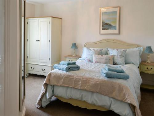 a bedroom with a bed with blue towels on it at Castle Holt in Otterburn