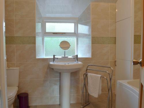a bathroom with a sink and a mirror and a window at Cosy Nook in Ambleside