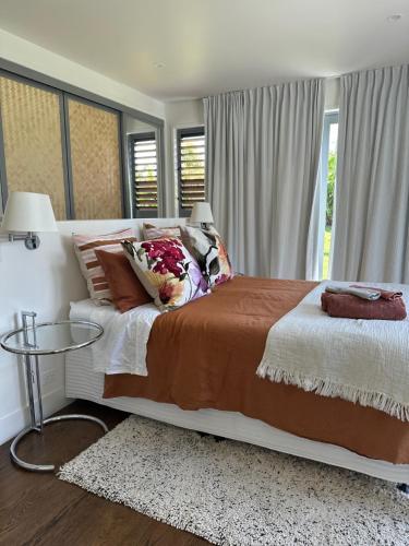 a bedroom with a large bed and a glass table at Mary's Tranquil B&B in Whangarei