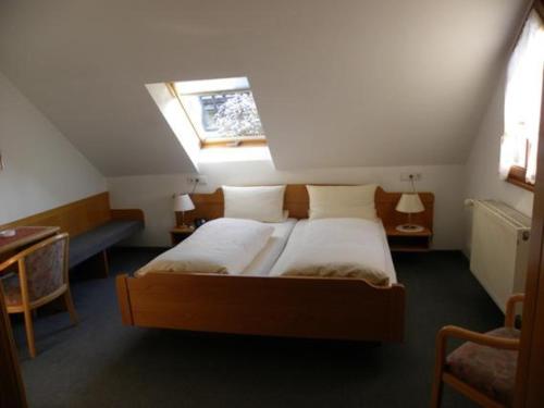 a bedroom with two beds and a window at Hotel Restaurant Adler Bühlertal in Bühlertal