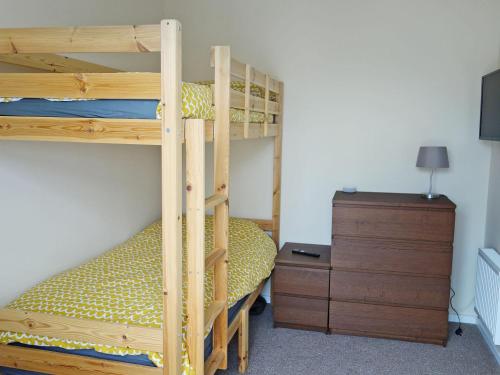 a bedroom with two bunk beds and a dresser at Deany Apartment in Bridlington