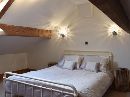 1 dormitorio con 1 cama con 2 luces en la pared en Bridge End, en Long Preston