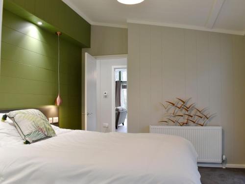 蘭福德的住宿－Lakeview Lodge，一间卧室配有一张白色的床和绿色的墙壁
