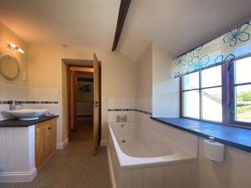 a bathroom with a large tub and a sink at Hazelrigg Farm in Newby Bridge