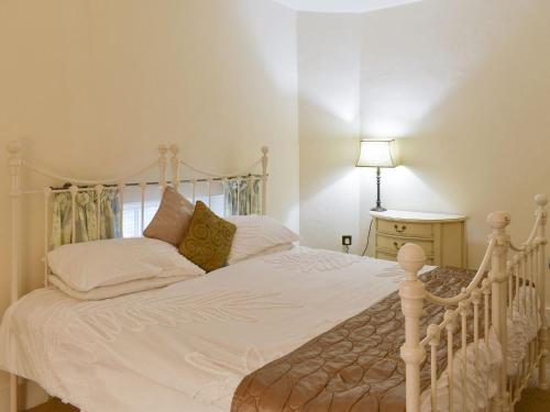 a bedroom with a white bed with a white comforter at Smithy Lodge At Heaton Park in Manchester