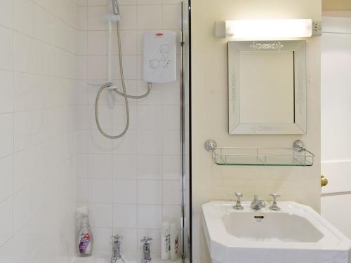 a bathroom with a shower and a sink and a mirror at Smithy Lodge At Heaton Park in Manchester