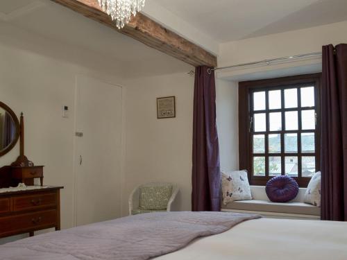 een slaapkamer met een bed en een raam bij Smithy House in Bampton