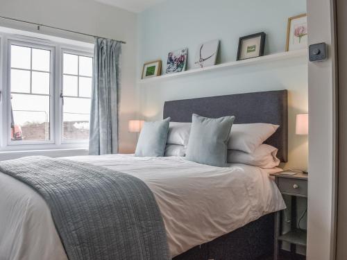 a bedroom with a large bed with pillows and a window at Hawthorn Cottage in Shirley