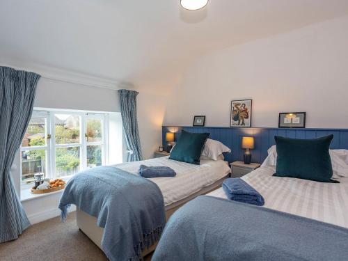 1 dormitorio con 2 camas y ventana en Box Tree Cottage, en Pickering