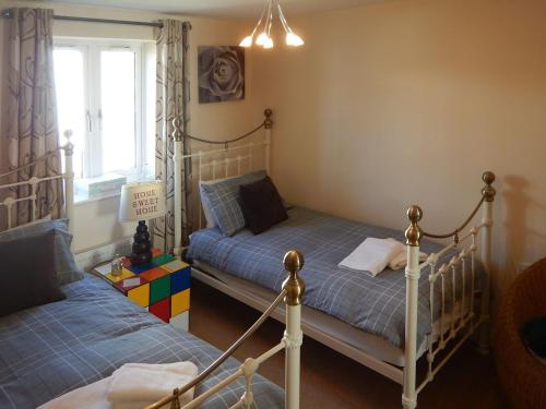 een slaapkamer met 2 bedden en een raam bij The Costal Hideaway in Sidmouth