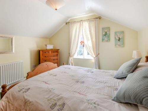 um quarto com uma cama grande e uma janela em Edlington Hall Cottage em Edlington
