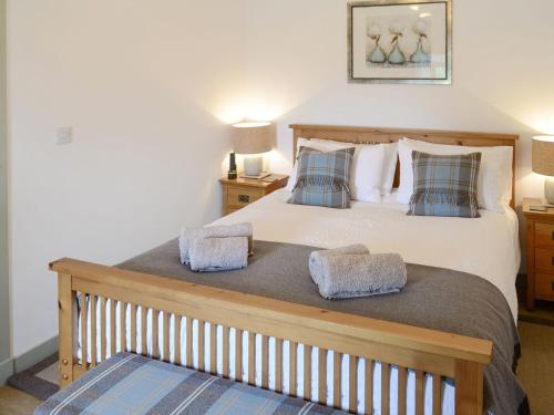 a bedroom with a large bed with two pillows at Sunset Cottage in Portmahomack