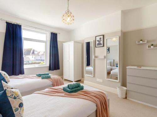 a bedroom with two beds and a mirror at Court House in Porthcawl