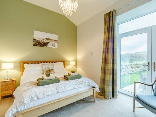 a bedroom with a bed and a large window at Merry Burn Barn - Uk3325 in Falstone