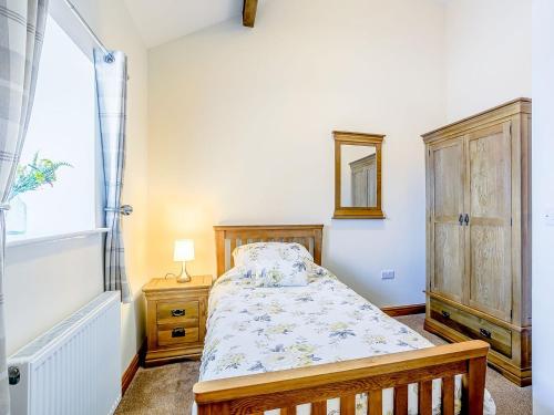 a small bedroom with a bed and a window at Shepherds Nook - Uk32388 in Dunford Bridge