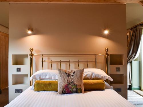 1 dormitorio con 1 cama grande con sábanas y almohadas blancas en Cosy Cottage - Uk34263 en Fordingbridge