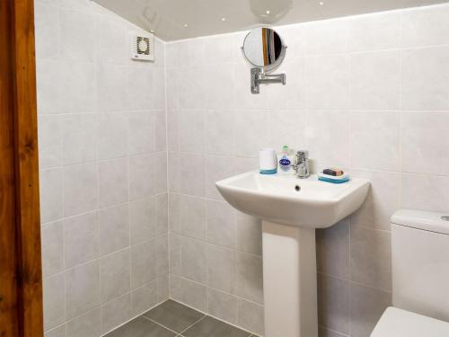 a white bathroom with a sink and a toilet at Oakwell Lodge in Rainham