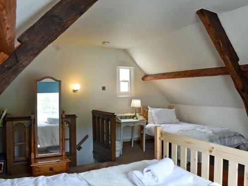a attic room with two beds and a mirror at 4 The Green in Richmond