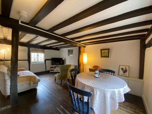 a room with a table and chairs and a bedroom at Dairy Farm in Sherfield English
