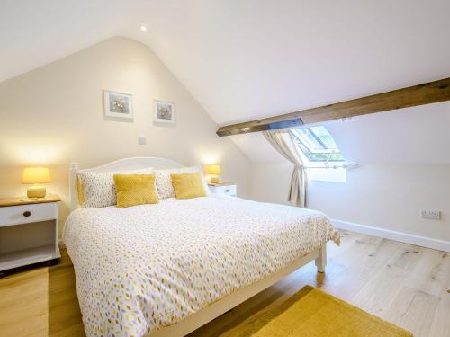 um quarto com uma cama com almofadas amarelas e uma janela em Horseshoe - Uk30759 em Bream