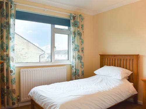 a bedroom with a bed and a large window at Torvean in Wareham