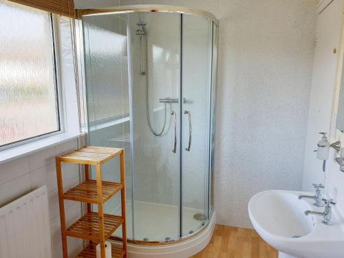 a glass shower in a bathroom with a sink at Torvean in Wareham