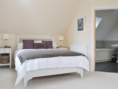 a white bedroom with a bed and a bath tub at Grieves Cottage - Uk11107 in Montrose