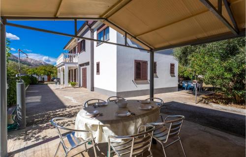 stół i krzesła siedzące pod namiotem na patio w obiekcie Cozy Apartment In Jurandvor w mieście Jurandvor