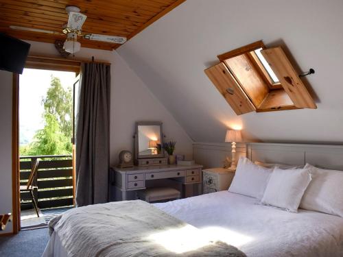 1 dormitorio con cama, escritorio y ventana en Hadrians Garden Cottage - Uk3323, en Bardon Mill