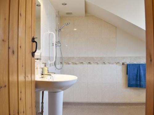 uma casa de banho com um lavatório e um chuveiro em Span Carr Cottage em Ashover