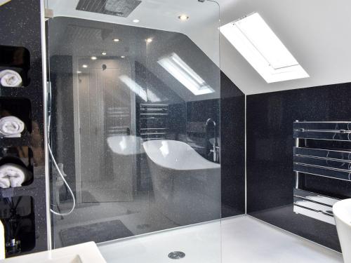 a bathroom with a bath tub and a sink at Chapel House in Bardon Mill