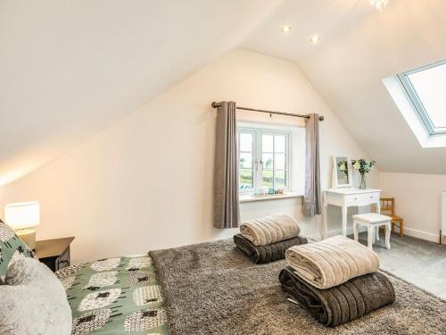 a attic bedroom with a bed and a window at South Carolina Farm House in Tansley