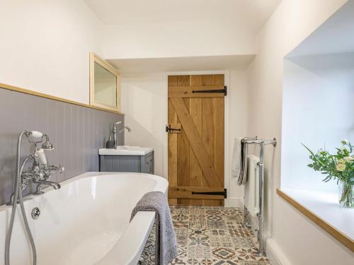 a white bath tub in a bathroom with a sink at South Carolina Farm House in Tansley