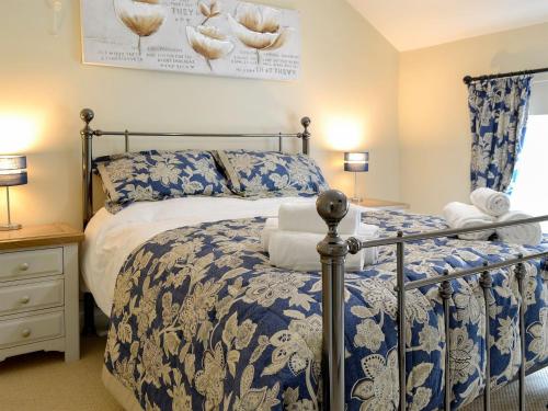 a bedroom with a bed with a blue and white comforter at Keldholme Cottages 2 - Uk11488 in Kirkbymoorside
