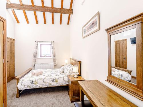 - une chambre avec un lit, une table et un miroir dans l'établissement Waters Edge - Uk32390, à Dunford Bridge