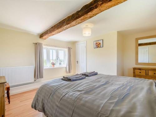 sypialnia z dużym łóżkiem i oknem w obiekcie Rathlin Cottage w mieście Cambridge