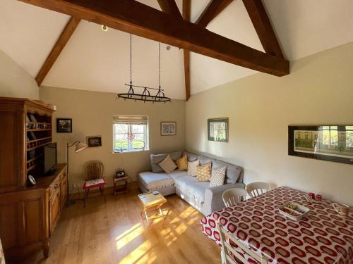 a living room with a couch and a bed at Le Jardin in Rodmarton