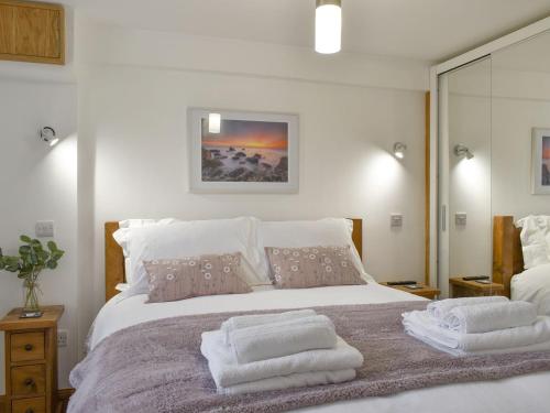 a bedroom with a large bed with towels on it at Tan Yr Ardd Bach in Llanwnda