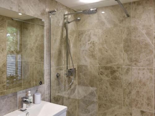 a bathroom with a shower and a sink at Tan Yr Ardd Bach in Llanwnda