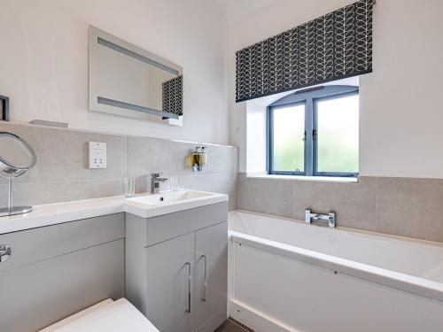 a bathroom with a sink and a tub and a toilet at The Coach House - Uk32461 in Burlton