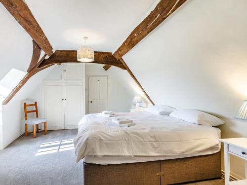 een slaapkamer met een groot bed op zolder bij Pattiswick Hall in Stisted