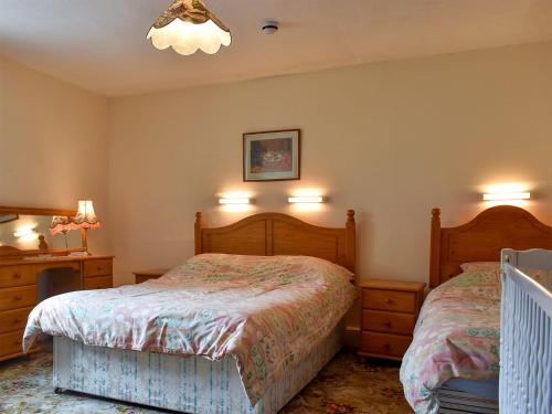 a bedroom with two beds and a chandelier at Hameldown-uk12423 in Widecombe in the Moor