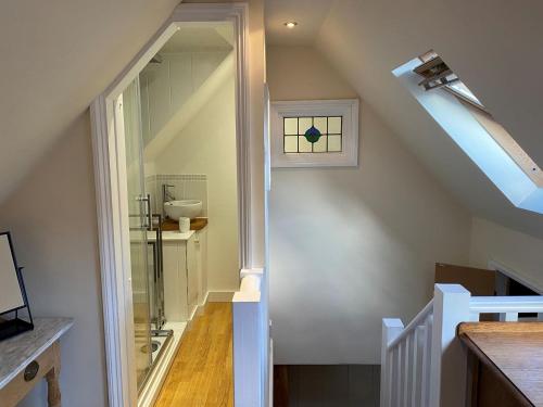 a bathroom with a staircase with a sink and a mirror at The Old Fire Station in Ivybridge